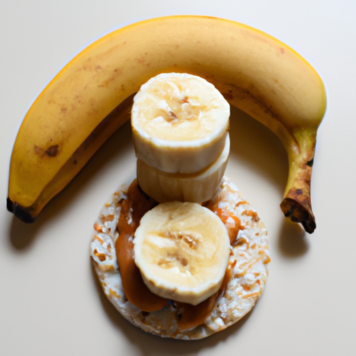 A ripe banana, almond butter, and two rice cakes arranged in a triangle.